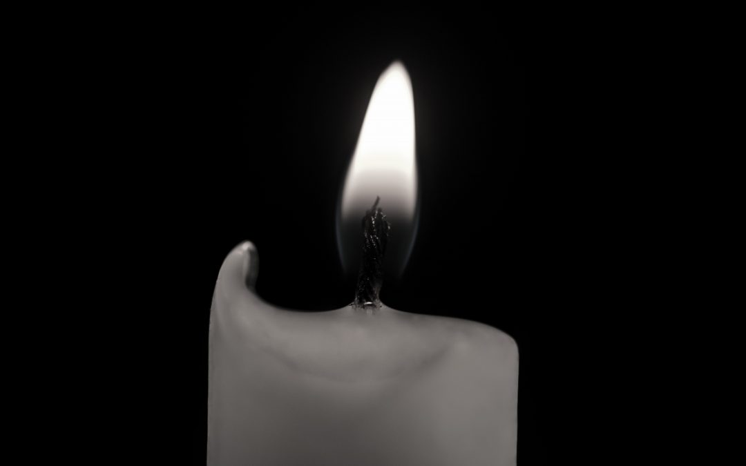 Czarno-białe zdjęcie płonącej świecy.