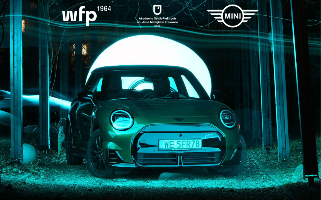 Zdjęcie przedstawia samochód marki MINI w zielonym świetle.