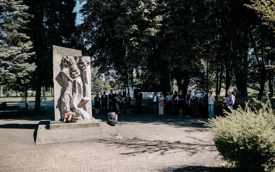 Pomnik upamiętniający ofiary podobozu KL Auschwitz-Jawischowitz na tle drzew.